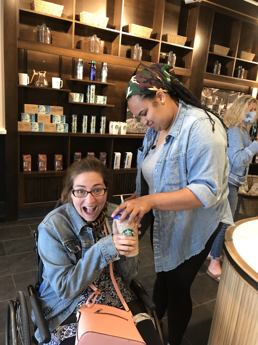 Robin Bennett taking a cup of Starbucks coffee from her sister excitedly. 