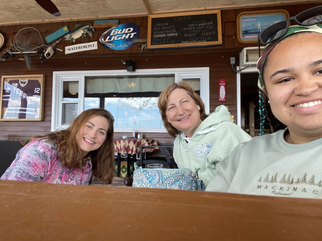 Robin Bennett, her mother, and her sister smiling at the camera while eating at a sit down restaurant in the Upper Peninsula of Michigan